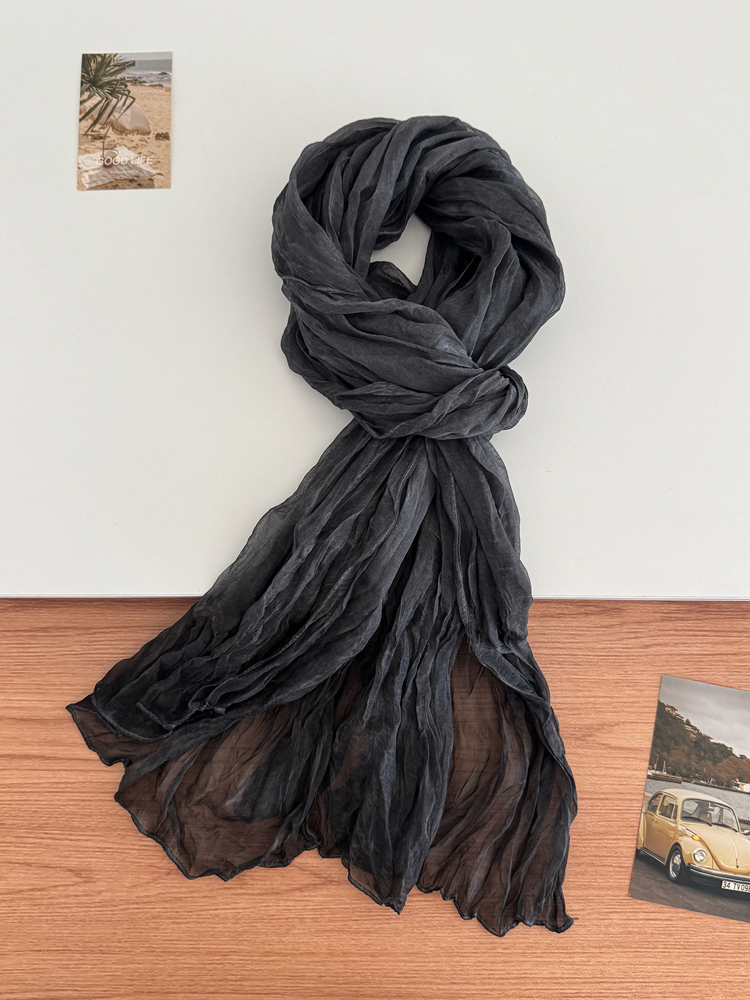 Black crinkled scarf arranged in a long drape