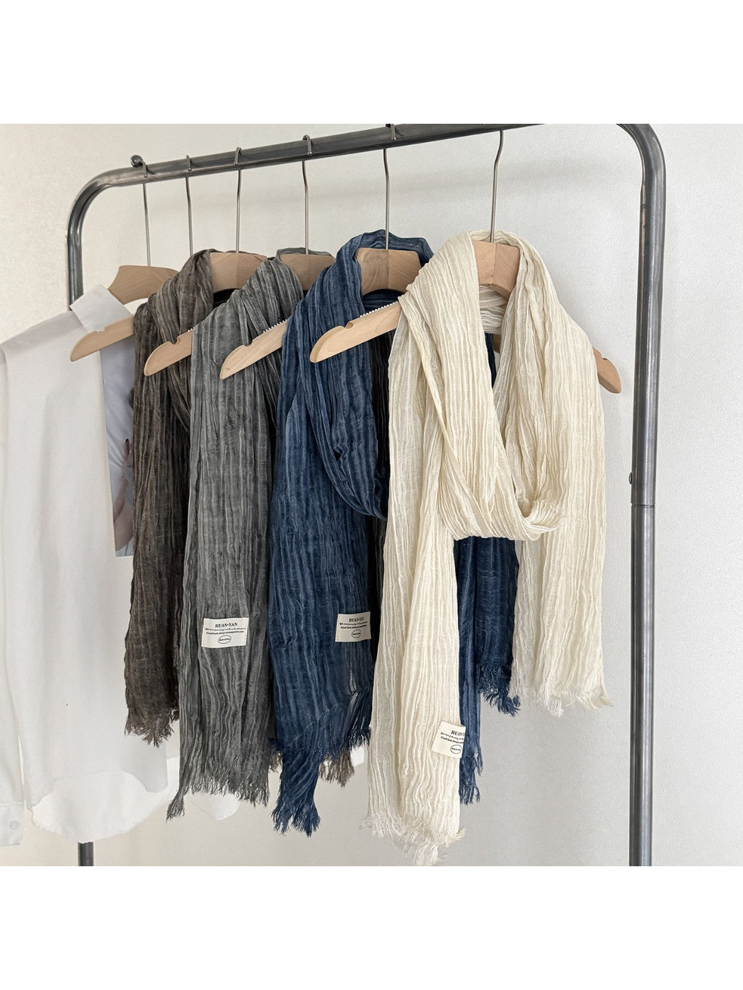 Cream, navy, gray and brown crinkled scarves displayed on hangers