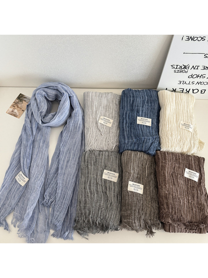 Gray Blue scarf draped beside folded scarves in multiple colors