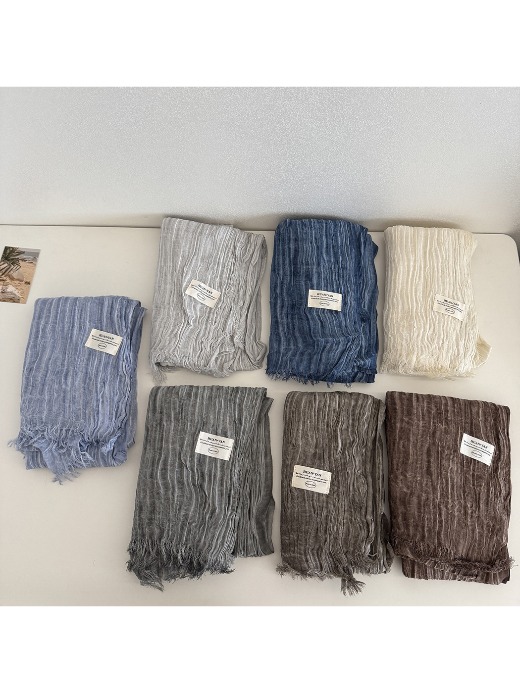 Seven crinkled scarf colors arranged in folded rows