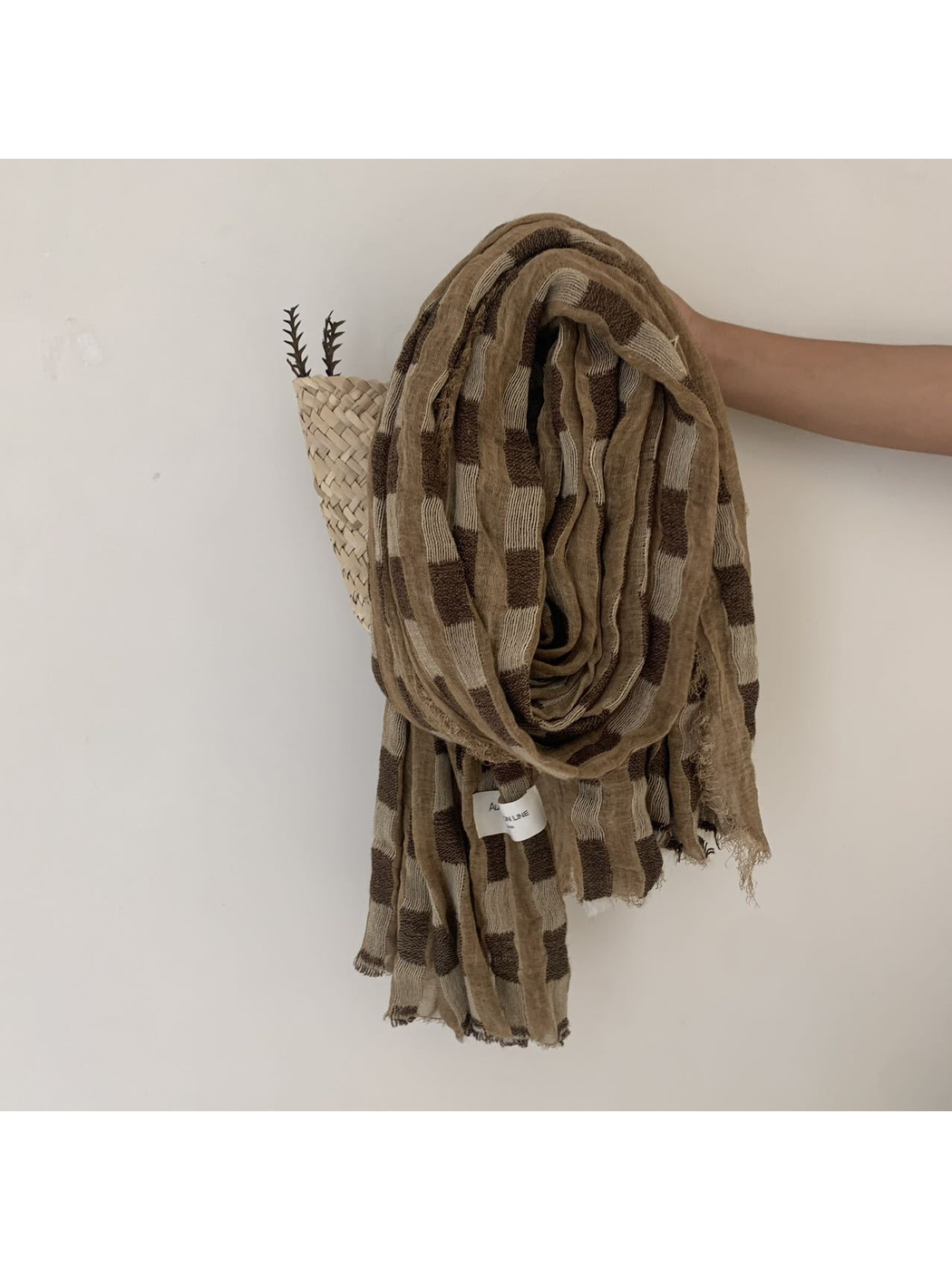 Camel checked scarf with an open weave and fringed edges