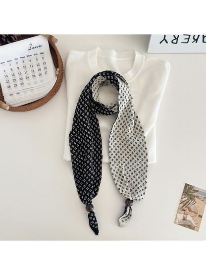 Black geometric-patterned narrow scarf with contrasting reverse and bead accents