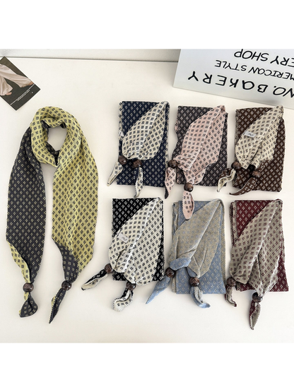 Seven color variations of the geometric-patterned narrow scarf displayed together