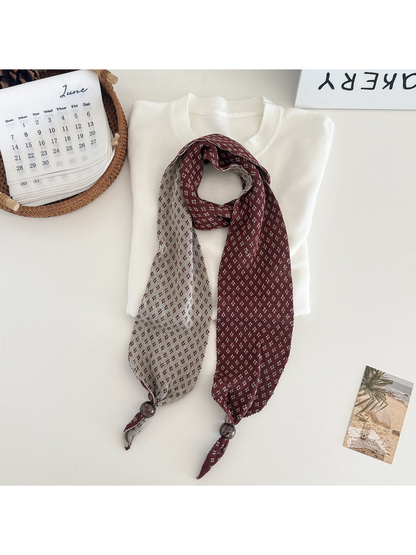 Burgundy geometric-patterned narrow scarf with contrasting reverse and bead accents
