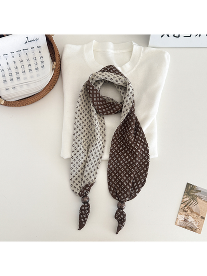 Brown geometric-patterned narrow scarf with contrasting reverse and bead accents