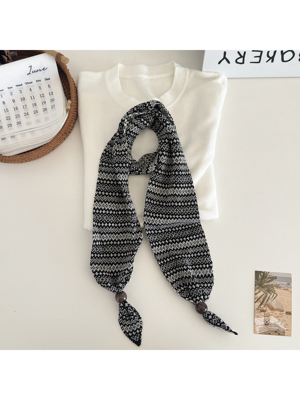 Black / White geometric-pattern narrow scarf with bead accents, flat display