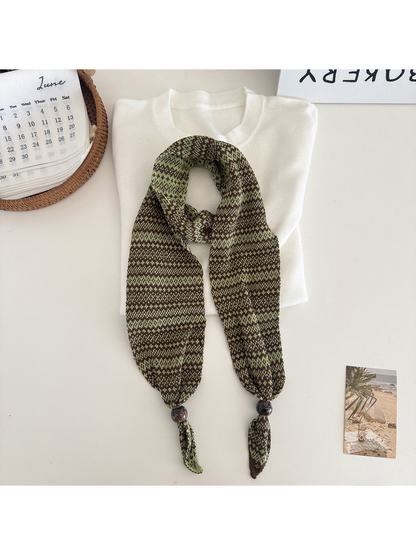 Green geometric-pattern narrow scarf with bead accents, flat display