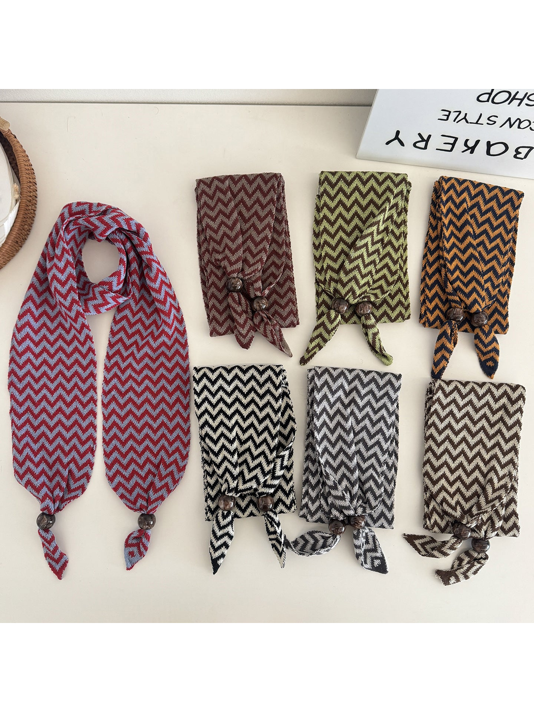 Zigzag scarves in seven colors displayed flat with bead-accented pointed ends