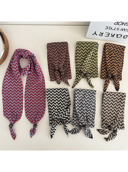 Zigzag scarves in seven colors displayed flat with bead-accented pointed ends