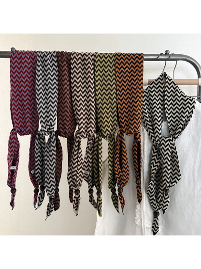 Seven zigzag scarf colors draped together on a clothing rack