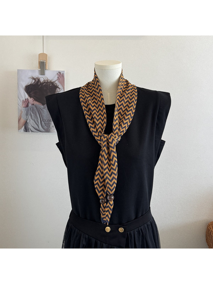 Caramel zigzag scarf tied in a long front knot on a black mannequin