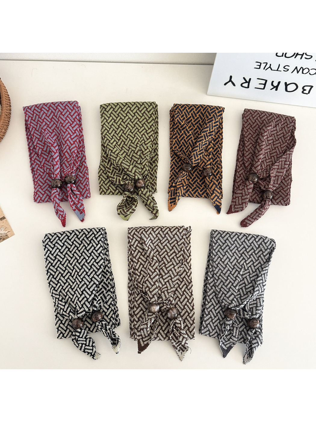 Seven folded geometric narrow scarf styles with beaded pointed ends