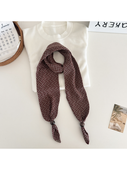 Burgundy Brown geometric narrow scarf with beaded pointed ends, flat lay
