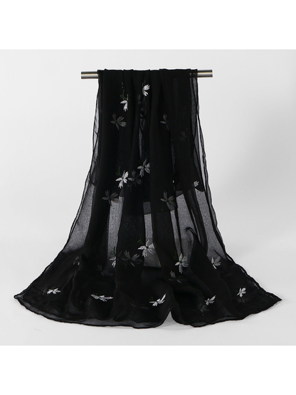 Black sheer scarf with scattered white floral embroidery, draped view