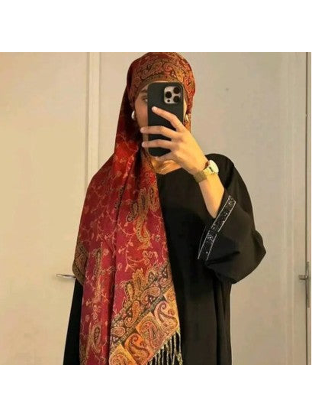 Red paisley scarf worn as a head covering in an indoor mirror view