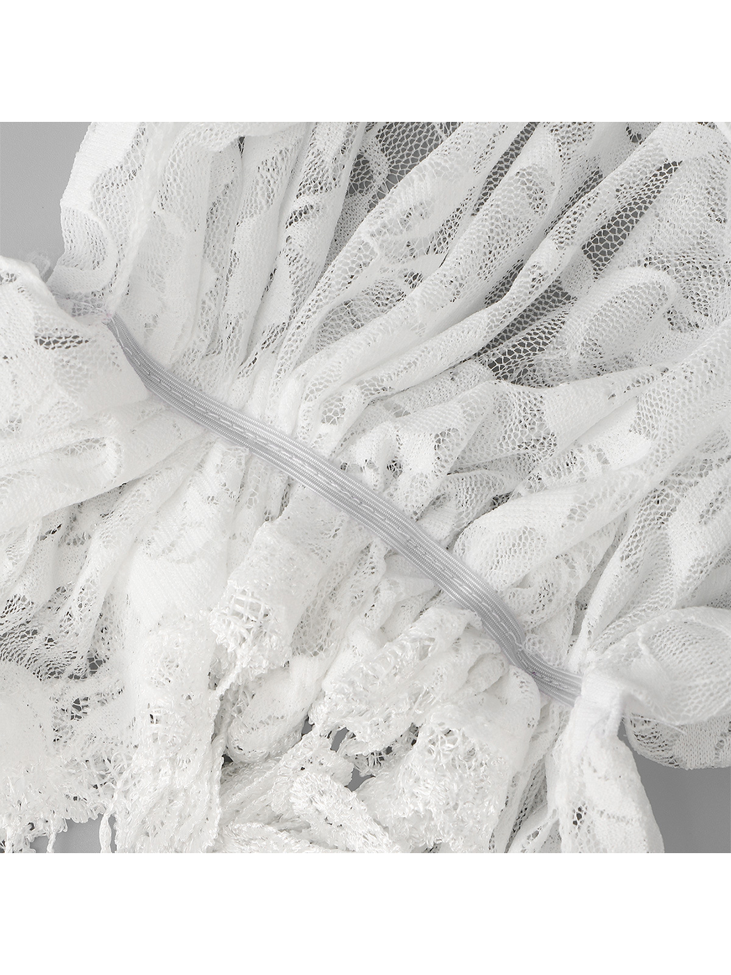 Close-up of the gathered back construction on the white floral lace headscarf