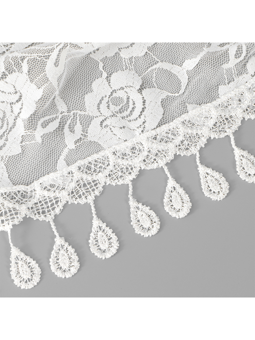 Close-up of white floral lace and teardrop fringe trim