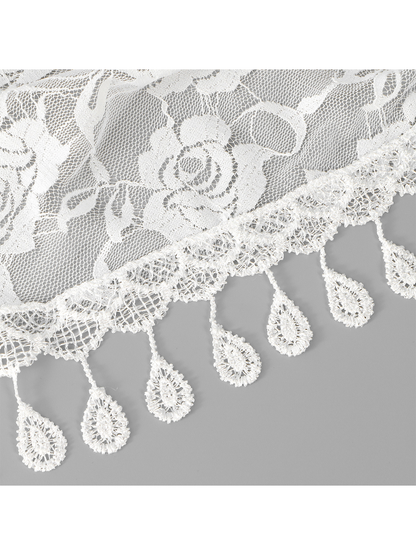 Close-up of white floral lace and teardrop fringe trim