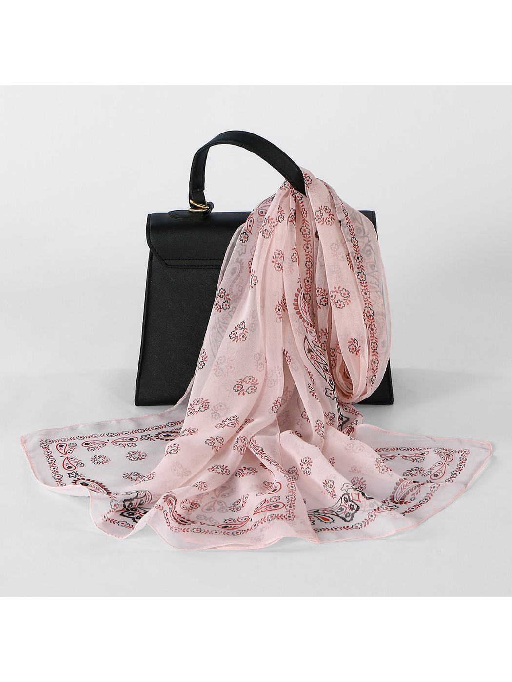 Pink Paisley sheer scarf draped over a black handbag