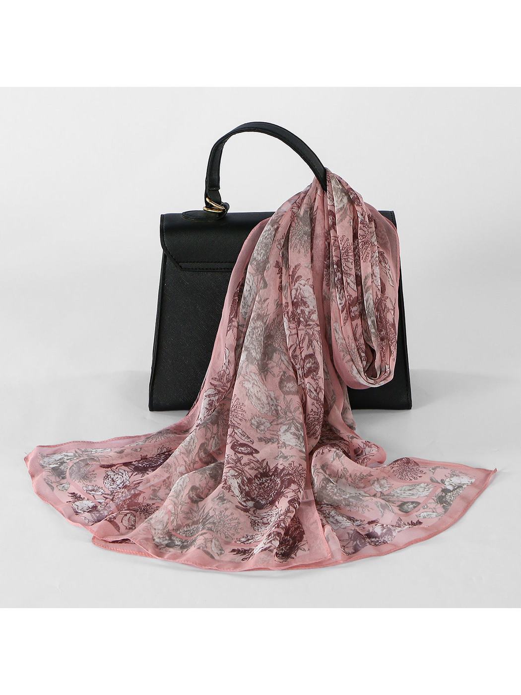 Pink Botanical sheer scarf draped over a black handbag