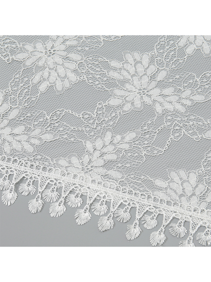 Close-up of white floral lace mesh and decorative fringe edging