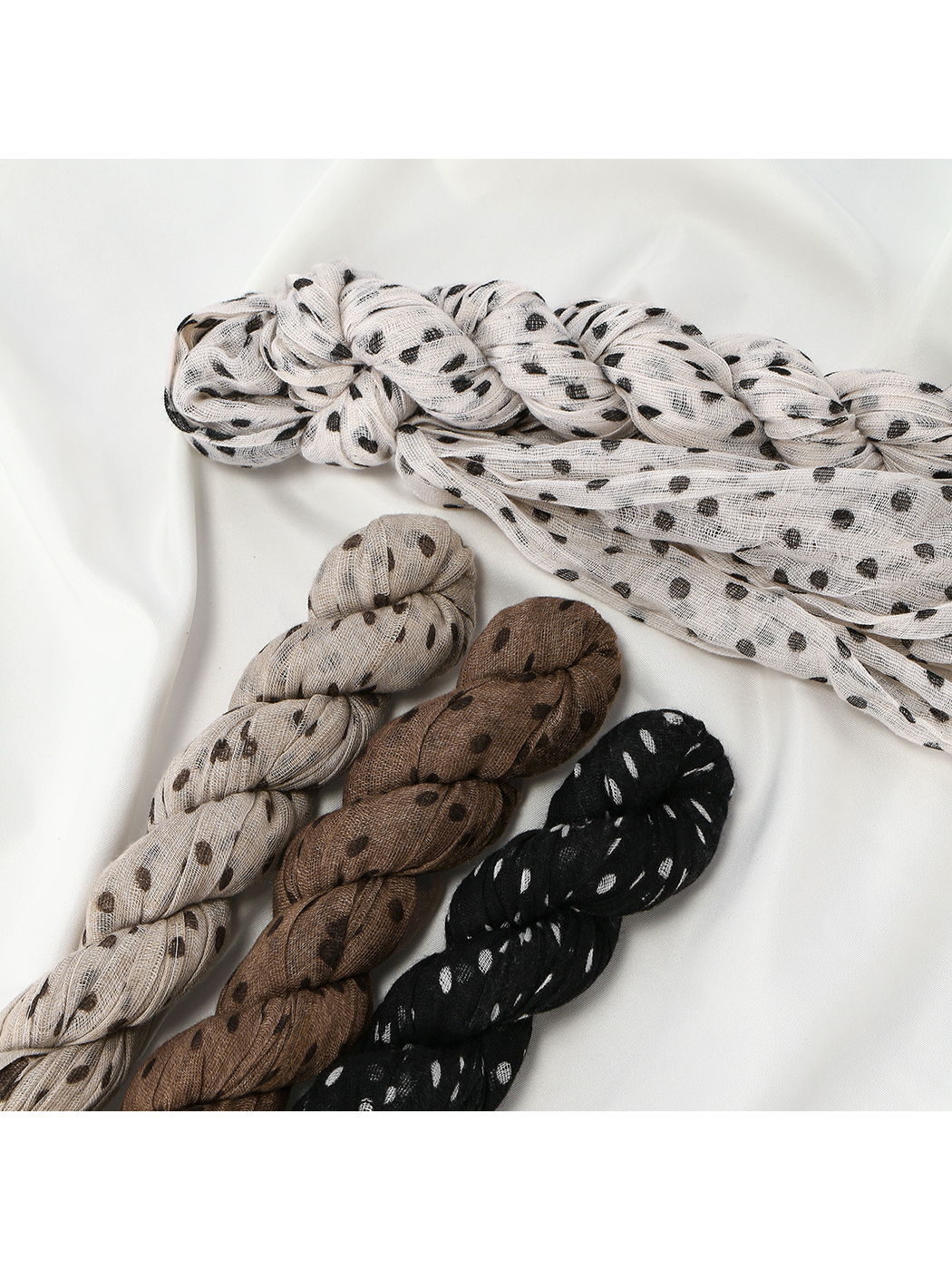 Close-up of braided crinkled dot scarves in four colors