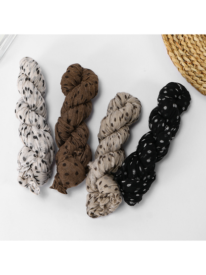 Four rolled crinkled dot scarves displayed together