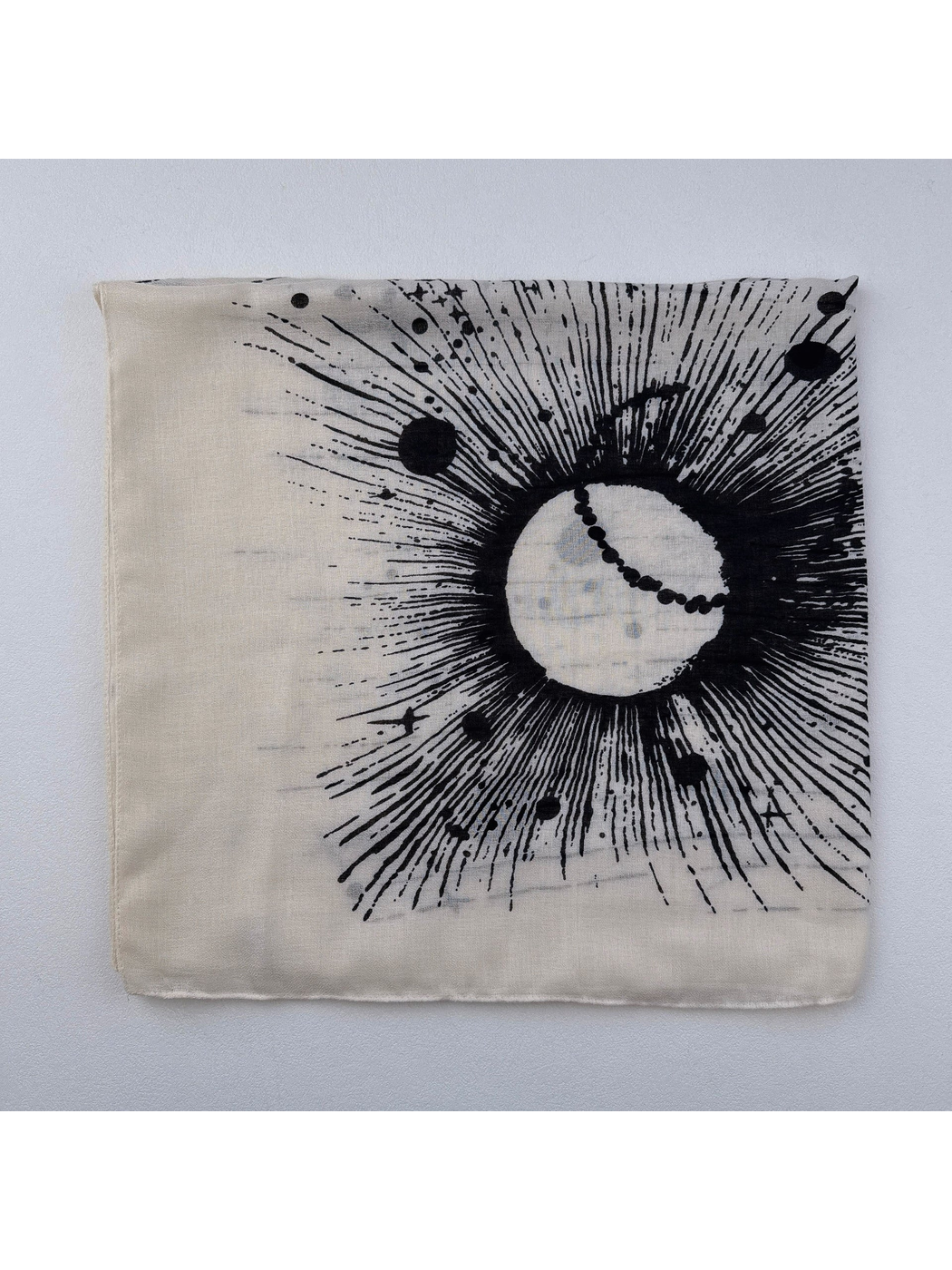 Close-up of the black circular sunburst, radiating lines and star-like marks on the scarf