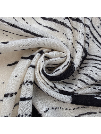 Close-up of the scarf's open semi-sheer woven texture and black abstract print