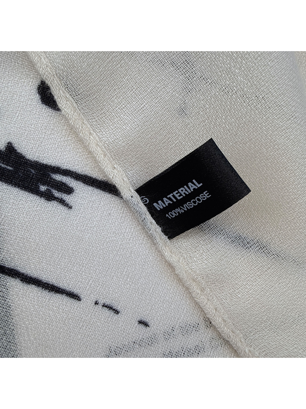 Close-up of the scarf's narrow finished edge and sewn-in black fabric label