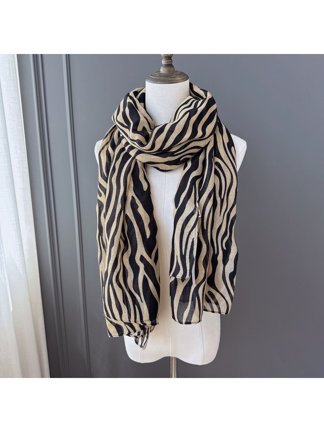 Brown animal-stripe scarf draped on a dress form