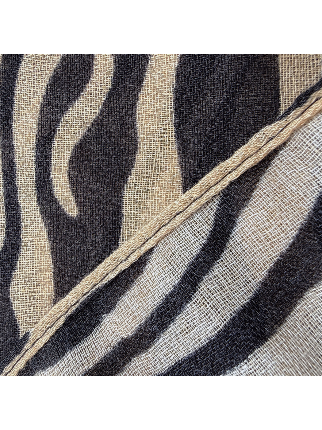 Close-up of the Brown scarf's narrow stitched edge and woven-look texture