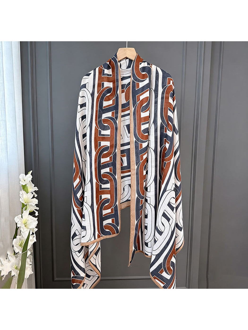 Multicolor geometric scarf hanging from a wooden hanger, full drape view