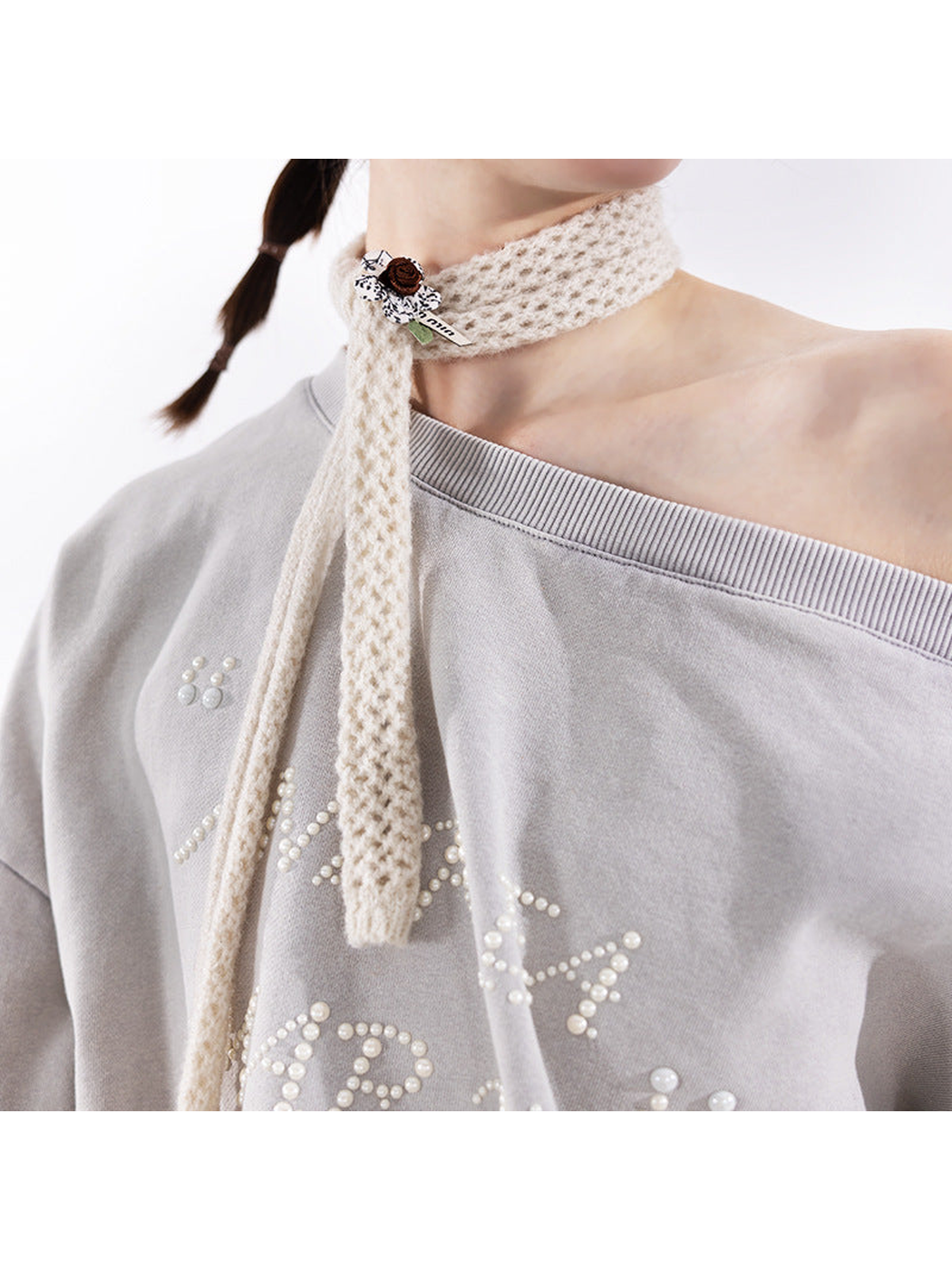 Close-up of the openwork scarf texture and floral appliqué