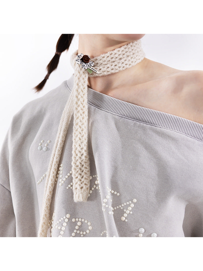 Close-up of the openwork scarf texture and floral appliqué