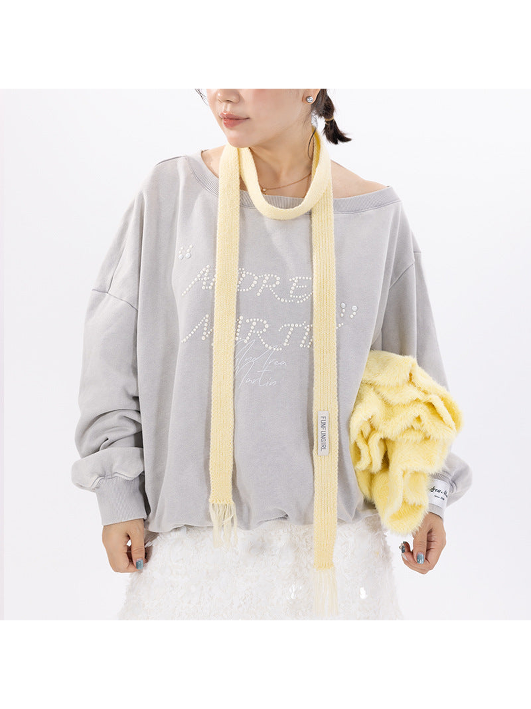 Yellow narrow knit scarf styled with a gray outfit