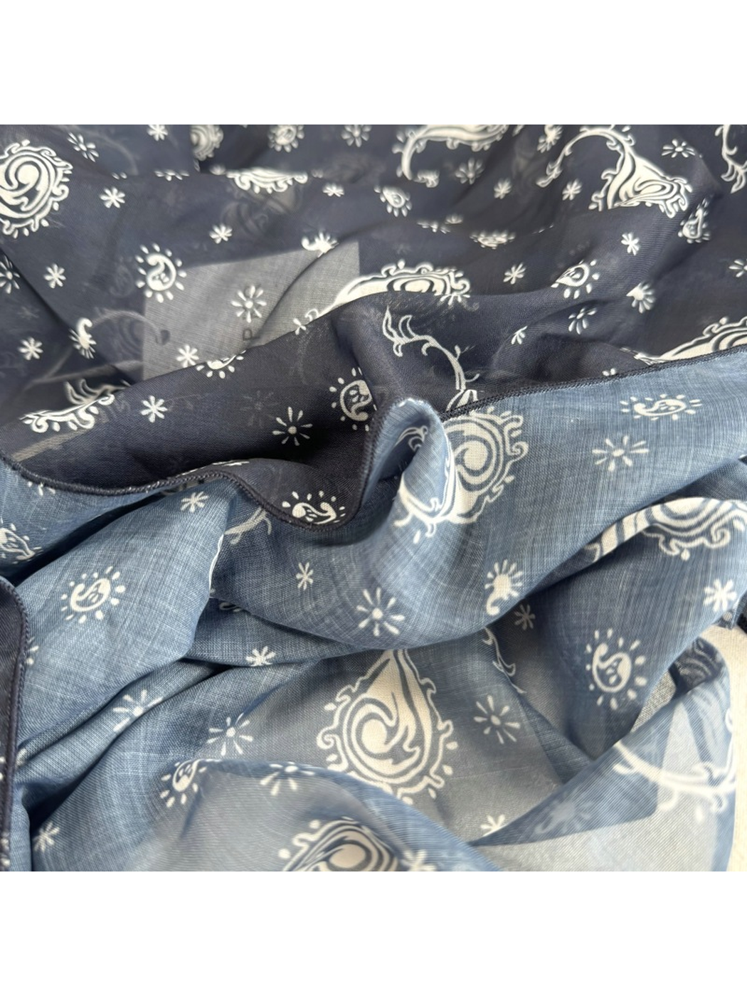Close-up of the Navy Paisley scarf pattern, sheer surface and finished edge