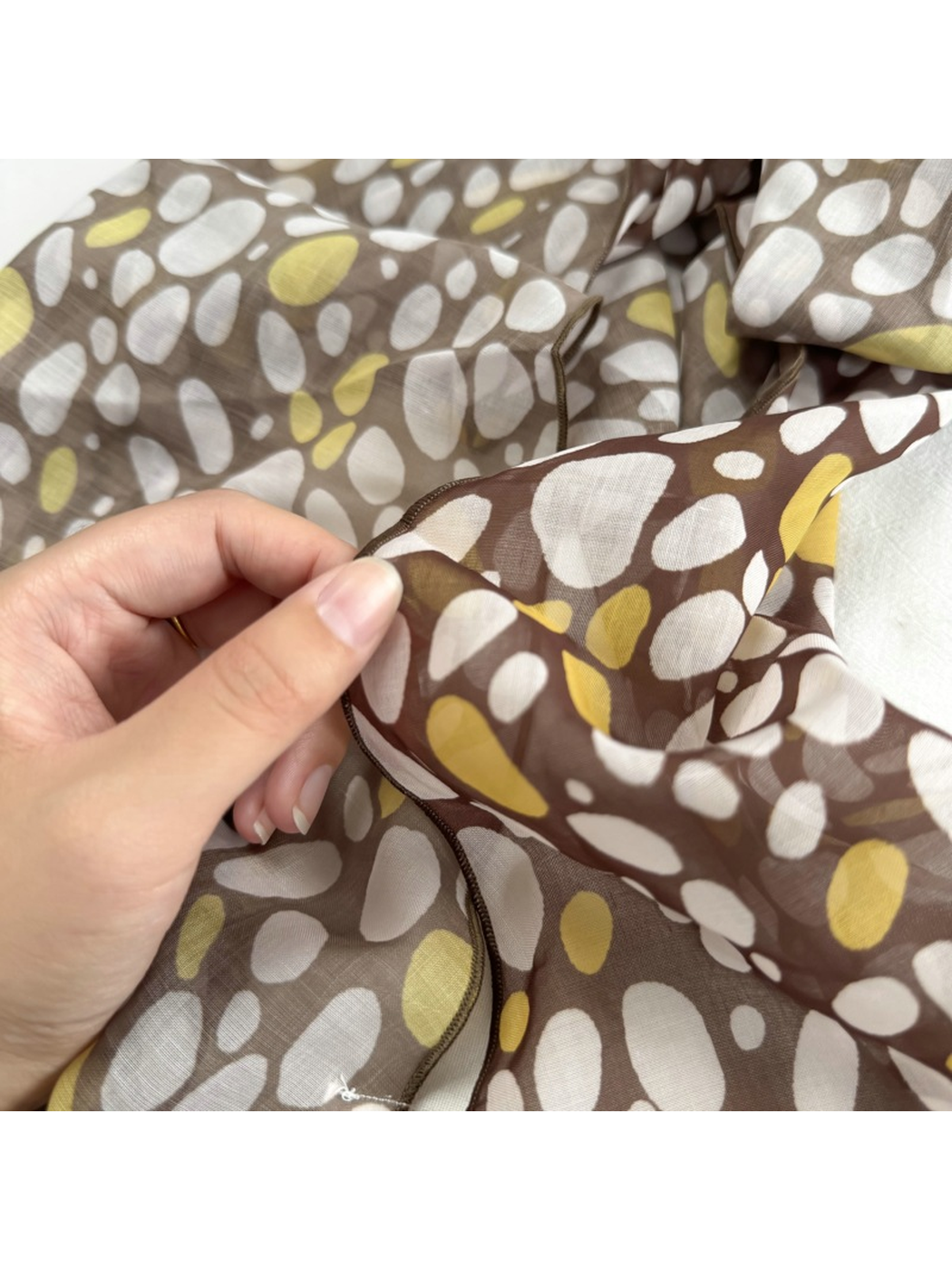 Close-up of the Pebble scarf pattern, sheer surface and stitched edge