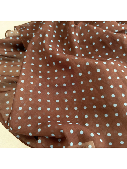 Close-up of the brown polka dot scarf and semi-sheer surface
