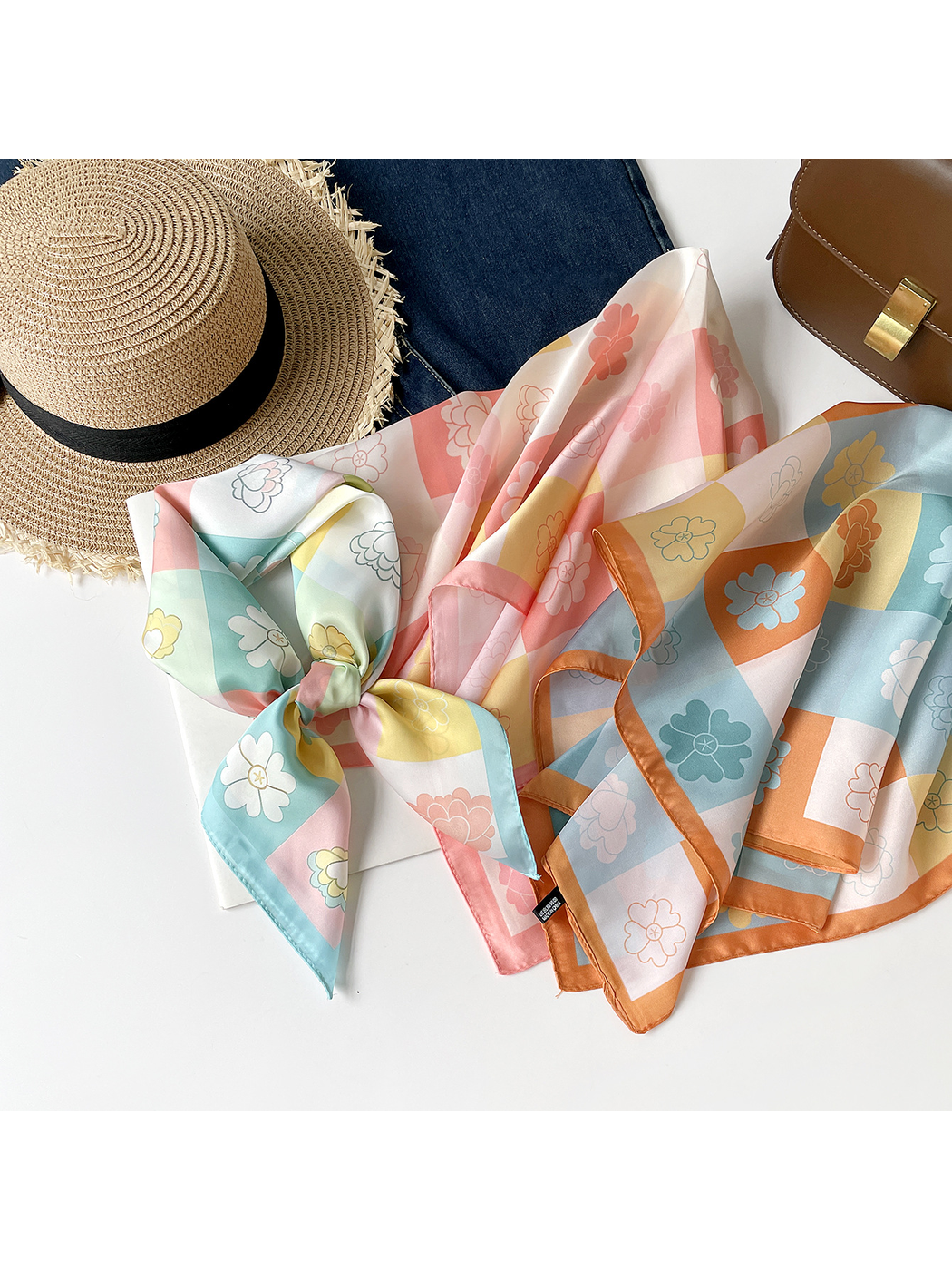 Three floral checkerboard square scarves arranged in mint, pink and orange colorways
