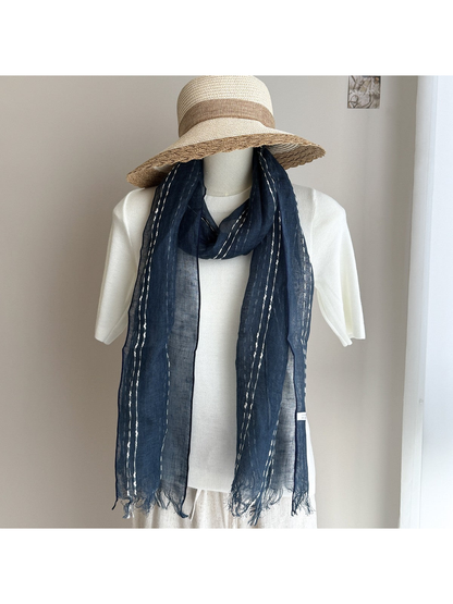 Navy striped scarf styled on a white mannequin with a wide-brim hat