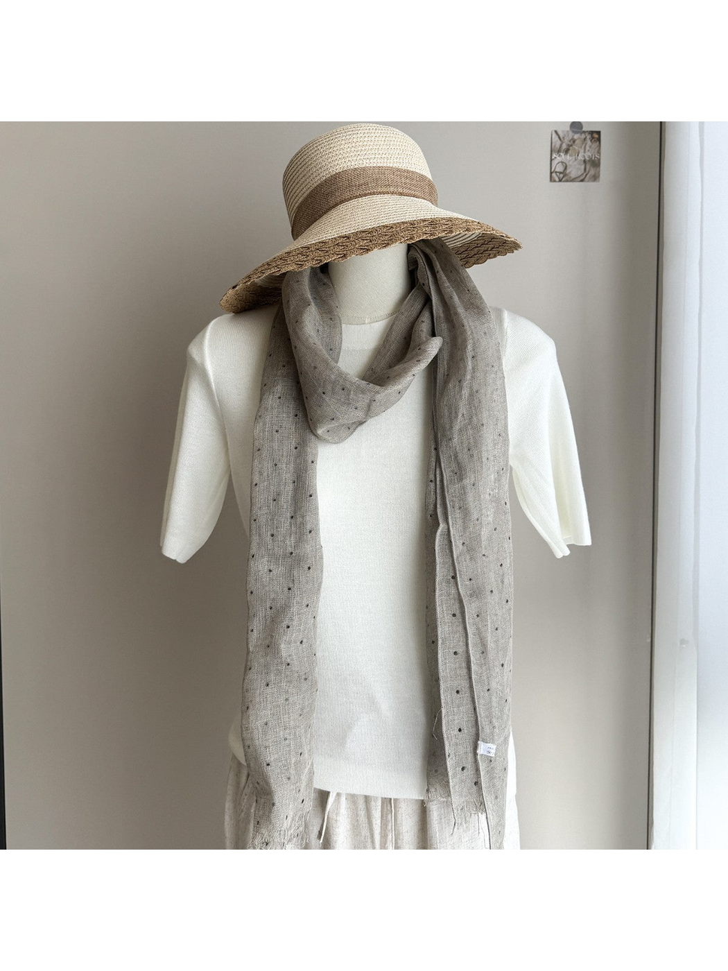 Greige dotted scarf styled on a white mannequin with a wide-brim hat