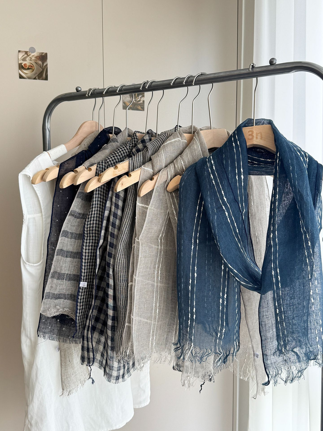 Assortment of patterned scarves hanging together on a clothing rack