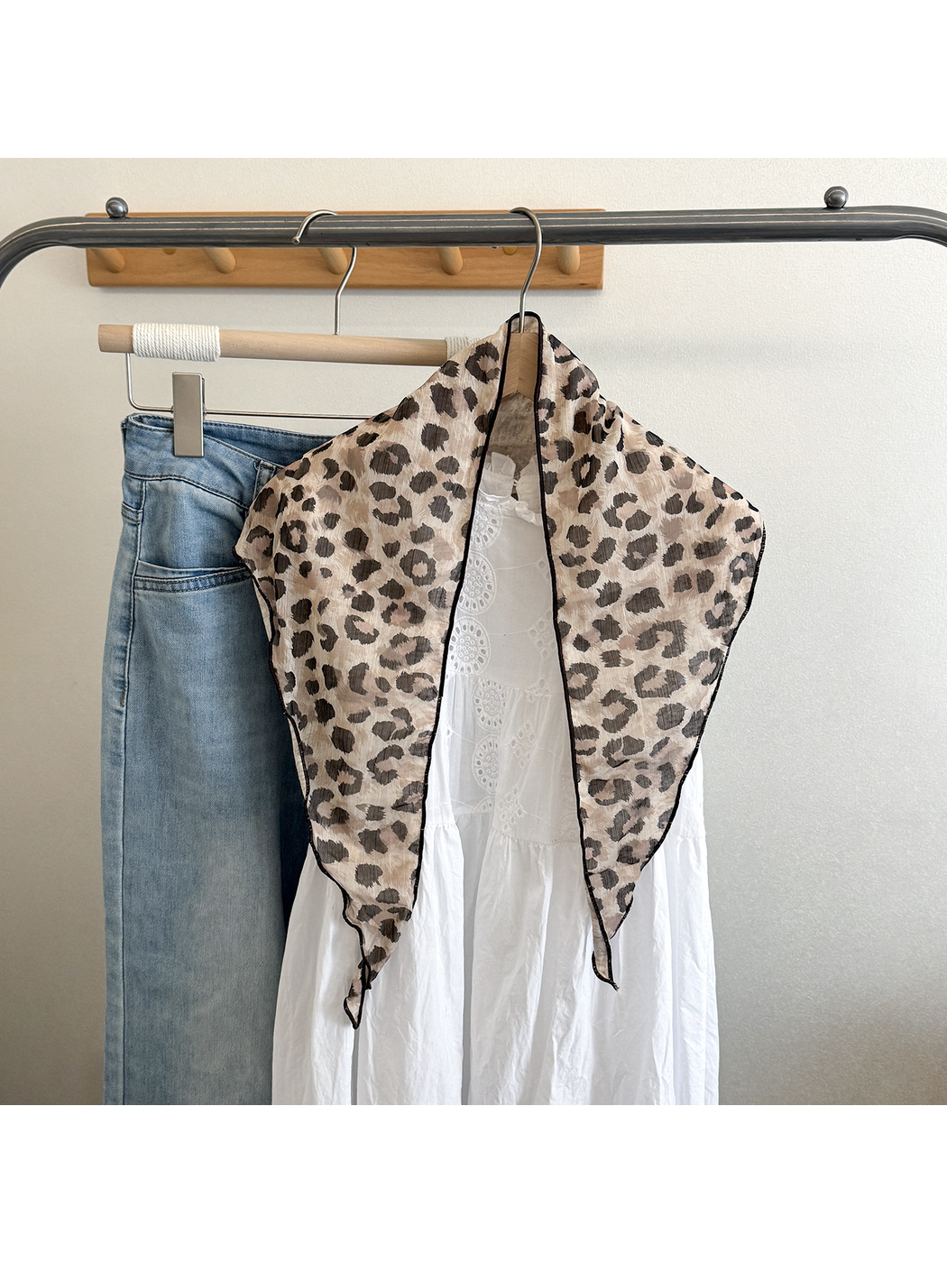 Leopard triangle scarf draped over a white dress