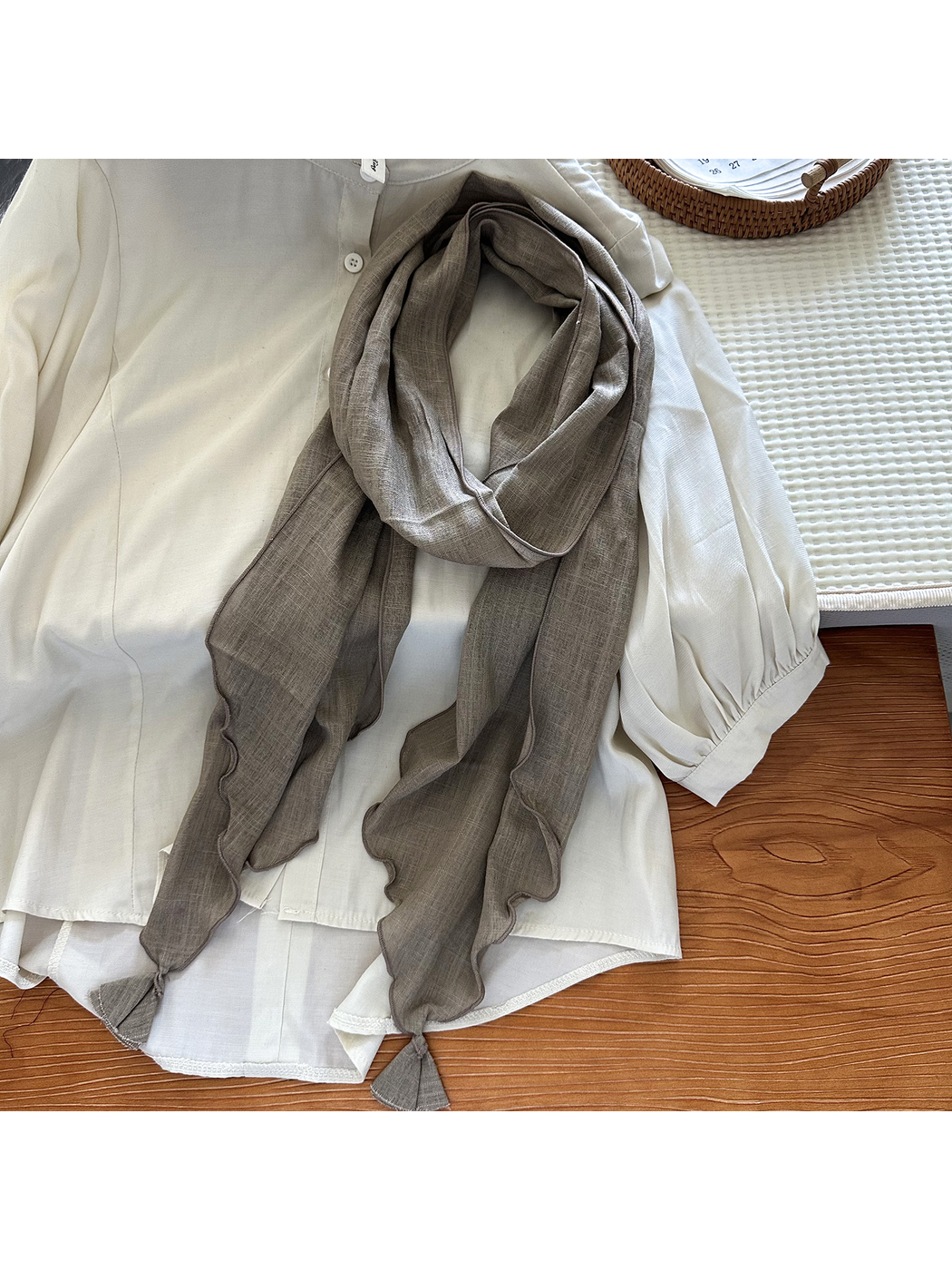 Khaki tassel scarf styled over an ivory blouse