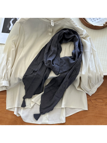 Dark Gray tassel scarf styled over an ivory blouse
