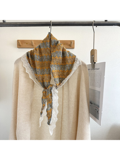 Yellow and gray striped triangle scarf styled over a cream top