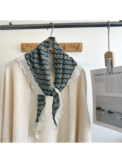 Blue and green striped triangle scarf styled over a cream top