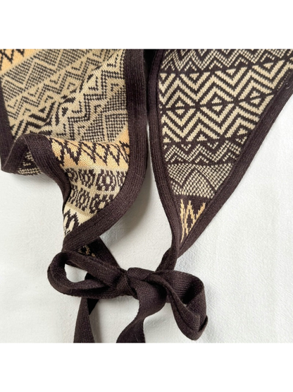 Close-up of the dark brown tie knot, border trim, and geometric pattern