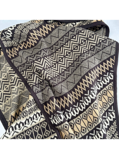 Close-up of folded geometric bands and dark brown edging